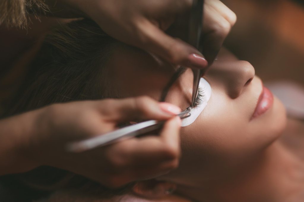 close-up-beautician-applying-extended-eyelashes-model