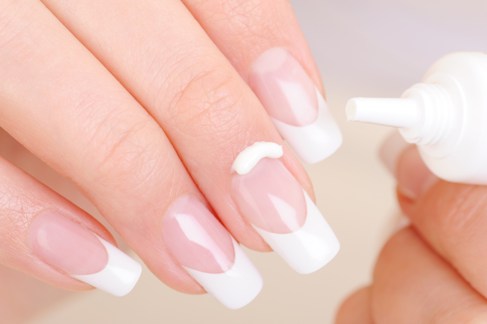 woman-caring-her-finger-applying-moisturizing-cosmetic-cream-fingernail